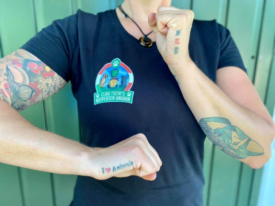 Frau mit schwarzem T-Shirt zeigt Tattos